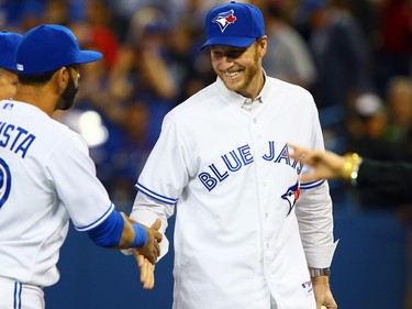Roy Halladay shakes hands with Jose Bautista before the Blue Jays' 2014 season opener (Dave Abel/Postmedia)