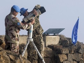 European members of United Nations Disengagement Observer Force (UNDOF) setup binoculars to watch the Syrian side of the Golan Heights as they stand in the Israeli-occupied Golan Heights on September 5, 2014. JACK GUEZ/AFP/Getty Images
