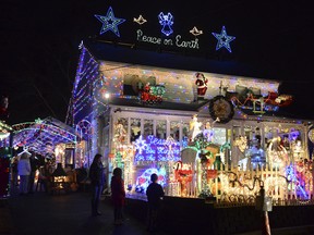 In this 2014 photo visitors look at the lights at 226 Roseville Terrace in Fairfield, Conn. The Connecticut family could be forced to turn off its intricate Christmas display decorated with 300,000 lights because of complaints from neighbors about traffic and parking. The Halliwells have been putting up the display for 18 years. (Christian Abraham/Hearst Connecticut Media via AP)