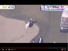 Japanese Prime Minister Shinzo Abe is seen falling after trying to get out of a bunker. (Video Screenshot)
