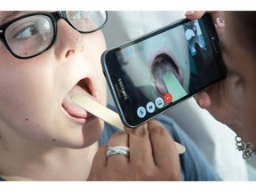 Doctor Thierry Castera examines the throat of a child via a smartphone held by a nurse during a digital medical consultation on September 12, 2016 in Oberbruck, eastern France. Electronic stethoscope connected to internet, smartphone to examine the back of the throat, diagnostic via webcam: in Oberbruck, an isolated village in the Vosges, patients visit the doctor... remotely, an innovation intended to address the shortage of practitioners in rural areas. SEBASTIEN BOZON/AFP/Getty Images

TO GO TO AFP STORY BY ARNAUD BOUVIER
SEBASTIEN BOZON, AFP/Getty Images