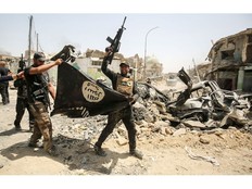 IRAQ-CONFLICT-MOSUL Members of the Iraqi Counter-Terrorism Service (CTS) cheer as they carry upside-down a black flag of the Islamic State (IS) group, with the destroyed Al-Nuri mosque seen in the background, in the Old City of Mosul on July 2, 2017, during the offensive to retake the city from IS fighters. Explosions on the evening of June 21, 2017 levelled the mosque where Abu Bakr al-Baghdadi gave his first sermon as leader of the Islamic State group, along with its ancient minaret. / AFP PHOTO / AHMAD AL-RUBAYEAHMAD AL-RUBAYE/AFP/Getty Images AHMAD AL-RUBAYE, AFP/Getty Images