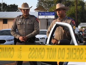 State troopers guard the entrance to the First Baptist Church (back) after a mass shooting that killed 26 people in Sutherland Springs, Texas on November 6, 2017.