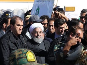 A handout photo provided by the office of Iranian President Hassan Rouhani shows him (C) during visit to the earthquake-hit area of Sarpol-e Zahab in Iran's western province of Kermanshah, where he promised on November 14, 2017 that the government would move swiftly to help those left homeless by the disaster. (Handout photo/AFP/Getty Images)