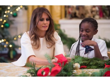 US First Lady Melania Trump makes garland with children in the East Wing as she tours holiday decorations at the White House in Washington, DC, November 27, 2017. SAUL LOEB/AFP/Getty Images