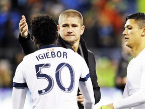 Vancouver Whitecaps coach Carl Robinson, center, reaches to give Nosa Igiebor a pat as Fredy Montero watches after the team lost to the Seattle Sounders in an MLS soccer Western Conference semifinal, Thursday, Nov. 2, 2017, in Seattle. (AP Photo/Elaine Thompson)