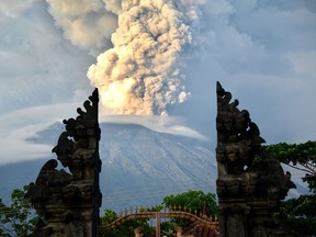 A general view shows Mount Agung erupting betwen Balinese a temple seen at night from Kubu sub-district in Karangasem Regency on Indonesia's resort island of Bali on Nov. 28, 2017.  (SONNY TUMBELAKA/AFP/Getty Images)
