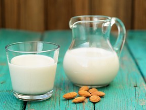 Homemade fresh almond milk in glass jar and glass bowl