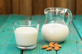 Homemade fresh almond milk in glass jar and glass bowl