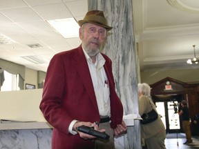 Rance Howard flashes a fake pistol prop for the film "Appleseed," in which Howard is costarring, inside Union Bank on Railroad Street in St. Johnsbury, Vt. (Dana Gray/Caledonian-Record via AP, File)