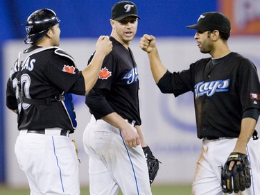 Roy Halladay with catcher Rod Barajas and third baseman Jose Bautista (Greg Henkenhaf/Postmedia)