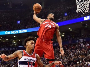 Toronto Raptors forward Norman Powell (24) dunks past Washington Wizards forward Kelly Oubre Jr. (12) during first half NBA basketball action in Toronto on Sunday.