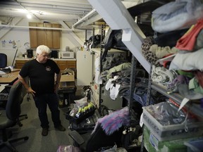 In this Tuesday, Nov. 21, 2017 photo, Terry Schoop, community services department manager for Burning Man festival, looks through some lost and found items at the organization's headquarters in San Francisco. Unclaimed items are listed on Burning Man's official website with photos and lot numbers. (AP Photo/Marcio Jose Sanchez)
