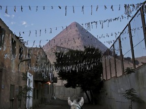 In this Nov. 17, 2016 file photo, a horse walks near the Great Pyramid, in Giza, Egypt. Scientists have found a previously undiscovered hidden chamber in Egypt's Great Pyramid of Giza, the first such discovery in the structure since the 19th century. In a report published in the journal Nature on Thursday, Nov. 2, 2017, an international team says the 30-meter (yard) void deep within the pyramid is situated above the Grand Gallery, and has a similar cross-section. (AP Photo/Nariman El-Mofty, File)