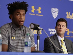 UCLA head coach Steve Alford, right, listens as Jalen Hill reads his statement during a news conference at UCLA Wednesday, Nov. 15, 2017, in Los Angeles.
