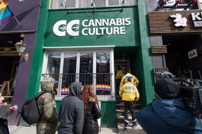 Store employees, media, and supporters are seen outside the Cannabis Culture store on Church St. during a police raid in Toronto on Thursday, March 9, 2017.