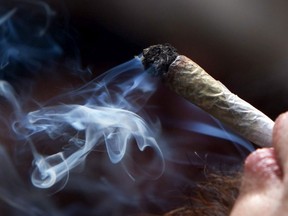 A young man smokes a marijuana joint during a rally in downtown Vancouver, B.C., on Wednesday April 20, 2011.