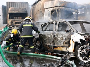 Firefighters work to put out fires in vehicles after a highway accident in Fuyang in central China's Anhui province, Wednesday, Nov. 15, 2017.  (Chinatopix via AP)