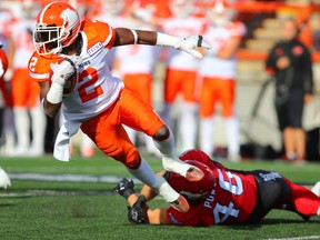 Lions' Chris Rainey is tripped up by Stampeders' Charlie Power during CFL action at McMahon Stadium in Calgary on Sept. 16, 2017. (Gavin Young/Postmedia Network)