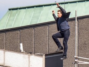 Tom cruise clings on in agony after crashing into a wall after jumping from one roof to another. (WENN.COM)