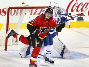 Flames' Matthew Tkachuk moves in front of Leafs defenceman NIkita Zaitsev to deflect the puck in Calgary on Tuesday night. (Jim Wells/Postmedia Network)
