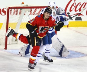 Flames' Matthew Tkachuk moves in front of Leafs defenceman NIkita Zaitsev to deflect the puck in Calgary on Tuesday night. (Jim Wells/Postmedia Network)