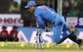 India's wicketkeeper Mahendra Singh Dhoni breaks the stumps to dismiss New Zealand's Tom Bruce during their third Twenty20 international cricket match in India, on Tuesday. (The Associated Press)