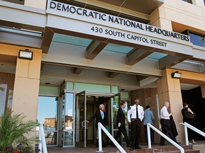 In this June 14, 2016 file photo, people stand outside the Democratic National Committee headquarters in Washington. (AP Photo/Paul Holston, File)