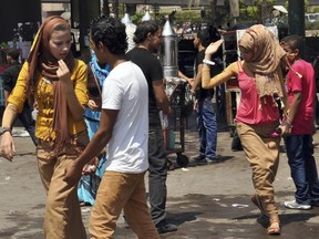 In this Aug. 19, 2012 file photo, Egyptian women are harassed by men on the first day of Eid al-Fitr holiday, in Cairo, Egypt.