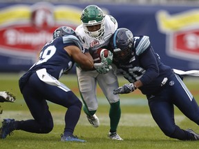 Roughriders wide receiver Marcus Thigpen is stopped by a pair of Toronto Argonauts defenders in Sunday's East final. THE CANADIAN PRESS/Mark Blinch