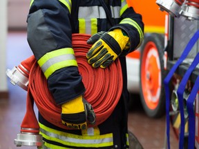 Firefighter wearing a rolled fire hose