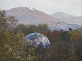 A globe and a ferris wheel stand in the forest near Bonn, Germany, during the UN Climate Conference on Nov. 13, 2017. (Rainer Jensen/dpa via AP)