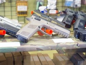 This stock photo shows an airsoft gun on a glass table in a shop.
