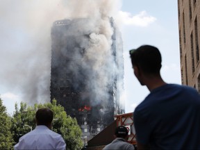 This file photo taken on June 14, 2017 shows pedestrians looking up towards Grenfell Tower.
