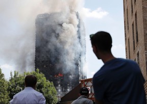 This file photo taken on June 14, 2017 shows pedestrians looking up towards Grenfell Tower.