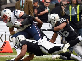 New England Patriots' Rob Gronkowski (L) is tackled during in a game against the Oakland Raiders on Nov. 19, 2017 at the Azteca Stadium in Mexico City. (ALFREDO ESTRELLA/AFP/Getty Images)