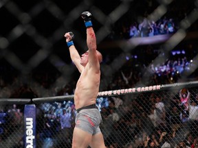Georges St-Pierre, of Canada, celebrates after winning a middleweight title mixed martial arts bout against England's Michael Bisping at UFC 217 early Sunday, Nov. 5, 2017, in New York. (AP Photo/Frank Franklin II)