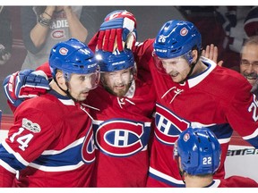 Montreal Canadiens' Paul Byron, centre, celebrates with teammates Tomas Plekanec, left, and Jeff Petry after scoring against the Buffalo Sabres during third period NHL hockey action in Montreal, Saturday, November 25, 2017. (THE CANADIAN PRESS/Graham Hughes)