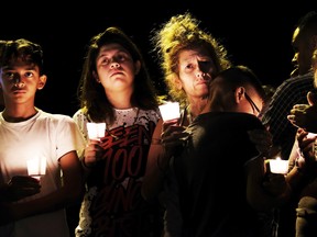 From left are Christopher Rodriguez, Esmeralda Rodriguez, Mona Rodriguez, Jayanthony Hernandez, 12 and Juanita Rodriguez, participate in a candlelight vigil held for the victims of a fatal shooting at the First Baptist Church of Sutherland Springs, Sunday, Nov. 5, 2017, in Sutherland Springs, Texas. (AP Photo/Laura Skelding)