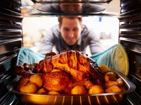 Man taking roast turkey out of the oven.