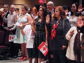 People take the Canadian citizenship oath at Pier 21 immigration centre in Halifax on July 1, 2017. (Adina Bresge/The Canadian Press)