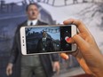 In this Wednesday, Nov. 8, 2017 photo, a visitor uses her mobile phone to take a photo of the wax figure of Adolf Hitler displayed against the backdrop of an image of Nazi Death Camp Auschwitz-Birkenau at De Mata Museum in Yogyakarta, Indonesia. (AP Photo/Slamet Riyadi)