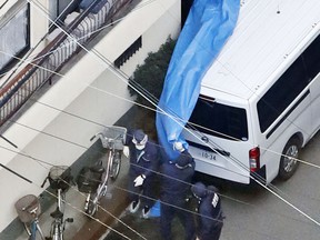 This Monday, Nov. 20, 2017 photo shows police investigation at an apartment where buckets filled with concrete were found, in Neyagawa, Osaka, western Japan. Japanese police say a woman went to a police station and confessed to putting four newborns in concrete-filled buckets two decades ago and having been filled with guilt over not caring for the babies. (Kota Endo/Kyodo News via AP)