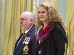 Governor General Julie Payette stands with the Dominion President of the Royal Canadian Legion Davi Flannigan after receiving the first poppy for the National Poppy campaign during a ceremony at Rideau Hall in Ottawa on October 23, 2017. Prime Minister Justin Trudeau says he is proud of Governor General Julie Payette for not hiding her passion for science after she used a speech at an Ottawa policy convention to criticize people who question climate change or believe in creationism. (Adrian Wyld/The Canadian Press)