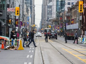 Pedestrians cross King St. W. at Peter St. Monday November 13, 2017 during the first work day of King Street Pilot Project in Toronto. Ernest Doroszuk/Toronto Sun/Postmedia Network