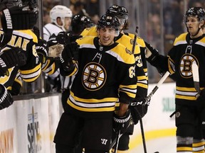 Boston Bruins' Brad Marchand is congratulated at the bench after scoring against the Los Angeles Kings during the first period of an NHL hockey game in Boston, Saturday, Oct. 28, 2017. (AP Photo/Winslow Townson)