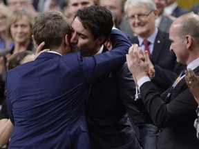Prime Minister Justin Trudeau hugs Veteran's Affairs Minister Seamus O'Regan after making a formal apology to LGBTQ2 people in Canada, in the House of Commons in Ottawa on November 28, 2017.