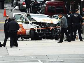 Investigators work around the wreckage of a Home Depot pickup truck a day after it was used in a terror attack in New York on November 1, 2017. The pickup truck driver who plowed down a New York cycle path, killing eight people, in the city's worst attack since September 11, was associated with the Islamic State group but "radicalized domestically," the state's governor said Wednesday. The driver, identified as Uzbek national named Sayfullo Saipov was shot by police in the stomach at the end of the rampage, but he was expected to survive. / AFP PHOTO / Jewel SAMADJEWEL SAMAD/AFP/Getty Images