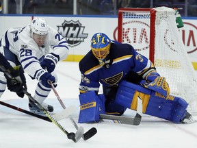 Toronto Maple Leafs' Connor Brown (28) reaches for a loose puck along side St. Louis Blues goalie Jake Allen during the first period of an NHL hockey game Saturday.  (AP Photo/Jeff Roberson)