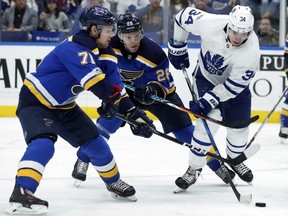 Toronto Maple Leafs' Auston Matthews (34) battles for the puck along with St. Louis Blues' Paul Stastny (26) and Vladimir Sobotka, of the Czech Republic, during the third period of an NHL hockey game Saturday, Nov. 4, 2017, in St. Louis. The Blues won 6-4. (AP Photo/Jeff Roberson)